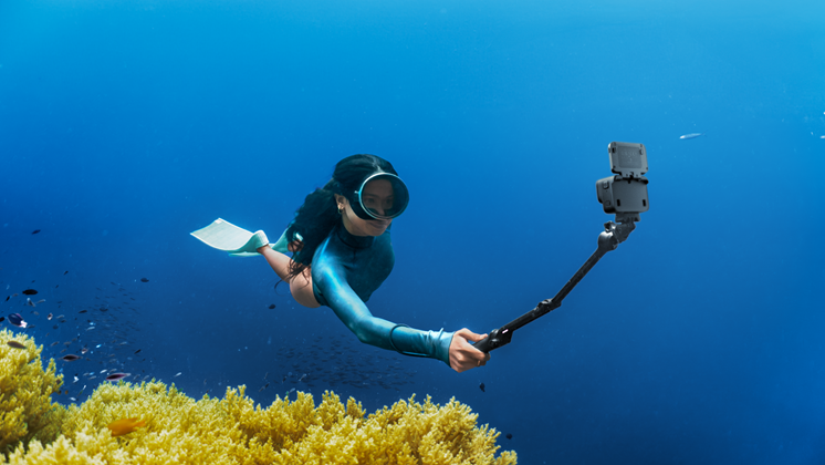 One woman is taking video while diving.